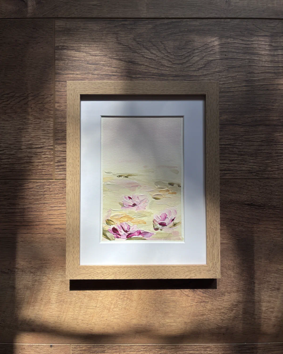 Soft Mist in a light oak frame, hanging on a wall in afternoon sunlight
